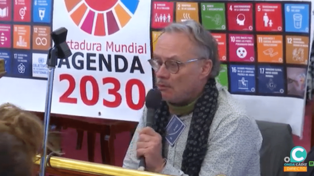 Uno de los intervinientes en el Pleno, con una pancarta contra la Agenda 2030 a sus espaldas.