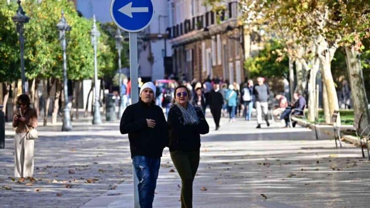 Varias personas pasean por la plaza de España en una fría y soleada mañana en Cádiz.