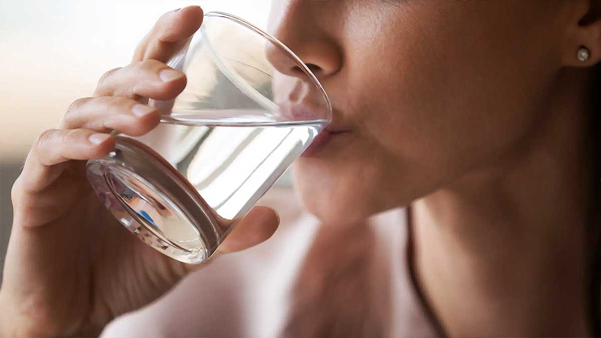 Persona bebiendo un vaso de agua.